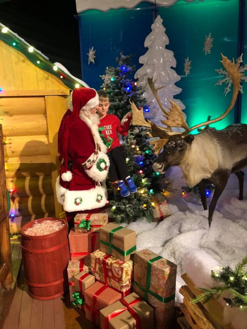 Santa, James Langley, carried Matthew Foster, 6, who is blind and autistic, over to feel the...