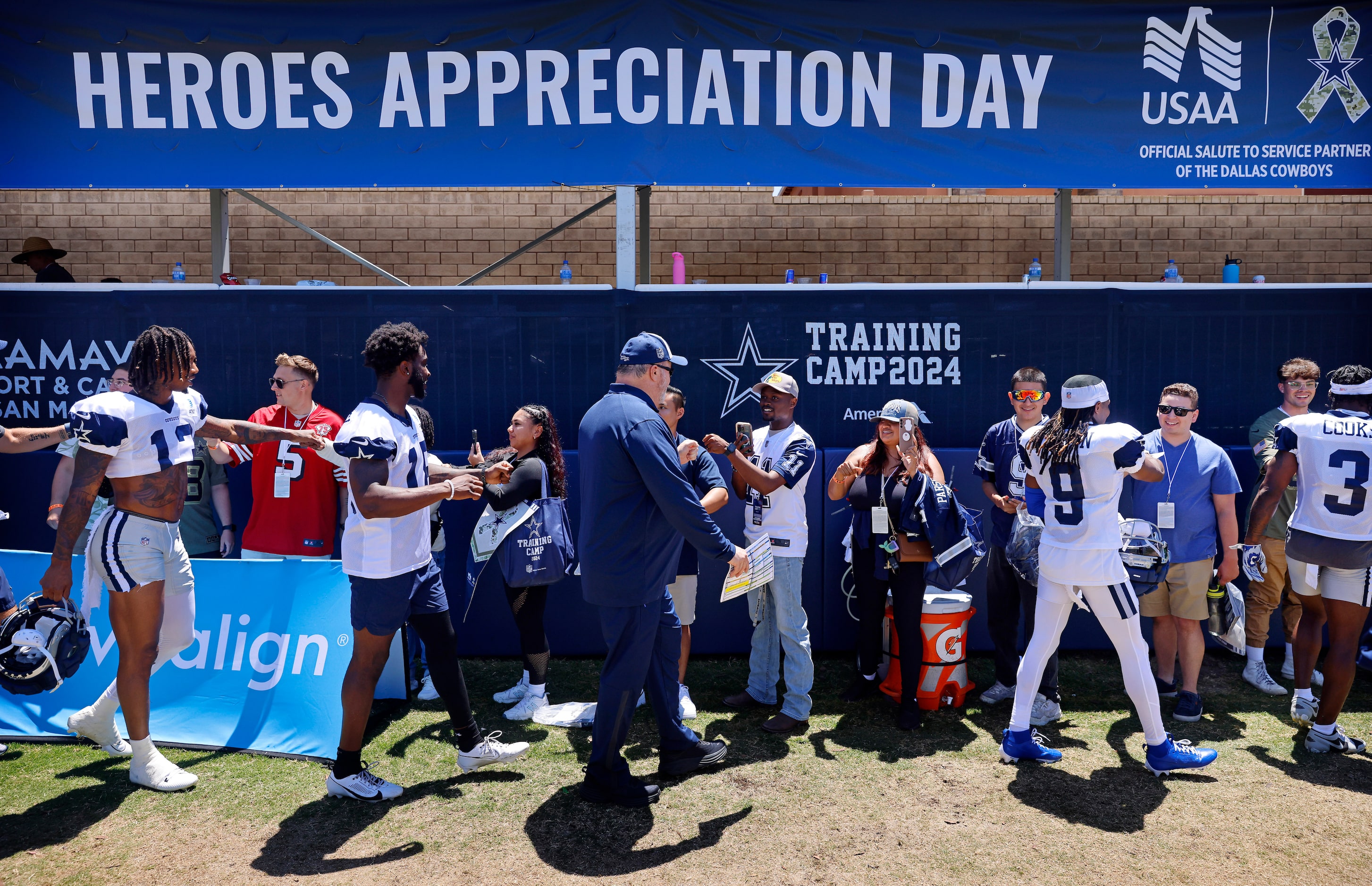 Dallas Cowboys players and coaches fist bumped military members and their families following...