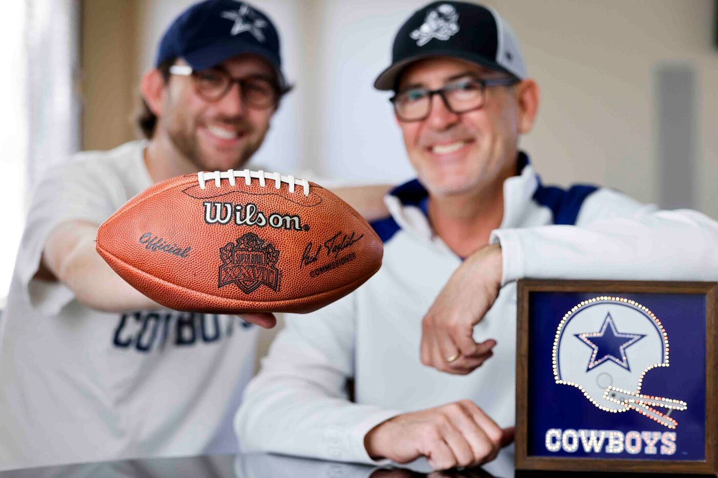 Cowboys fans Miles, left, and his father Marc Andres poses for portrait session with the...