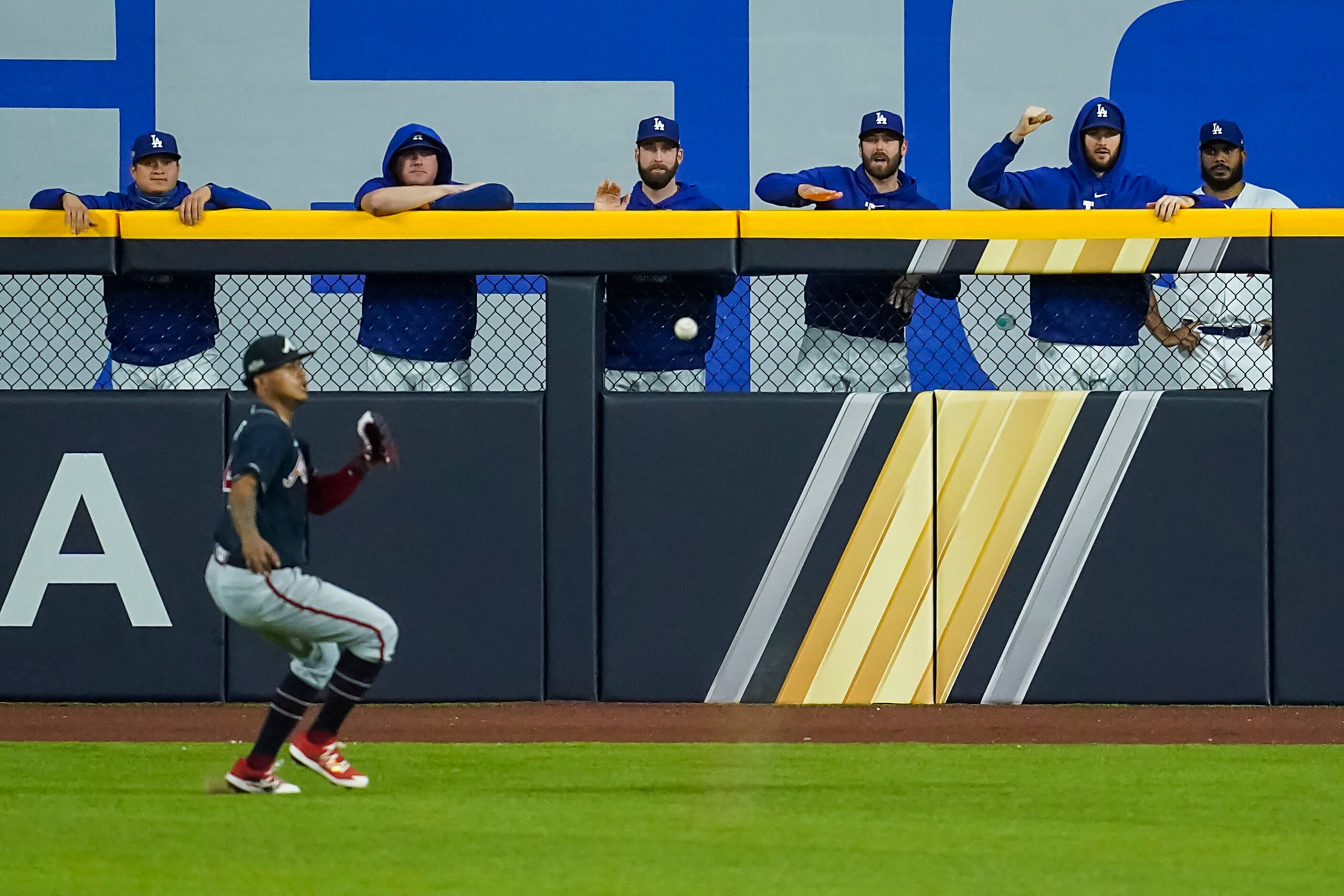 The Los Angeles Dodgers bullpen cheers as Atlanta Braves center fielder Cristian Pache runs...