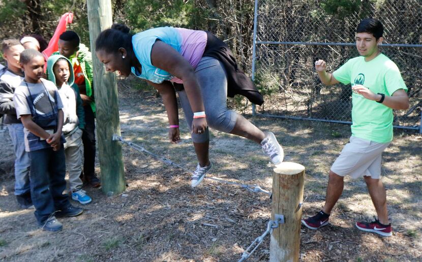 Sakia Baker tries to balance on a wire as Cameron Hernandez (right), challenger course...