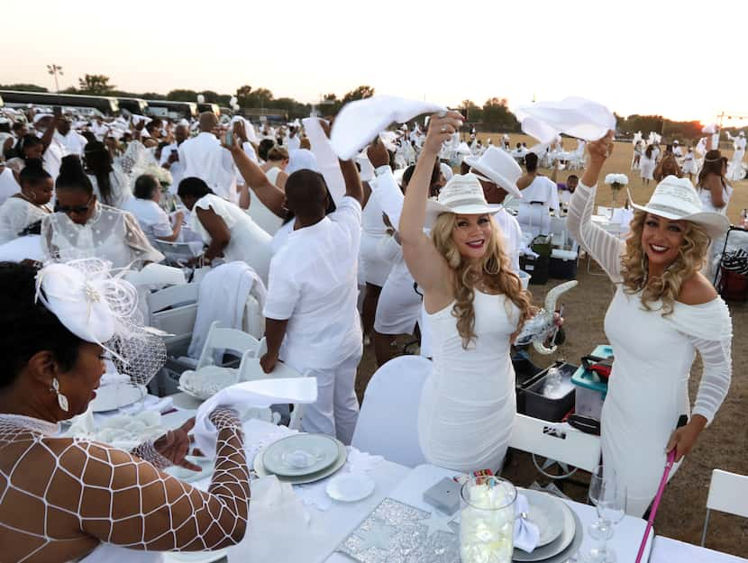 Guests wave their napkins during the Diner en Blanc event at Southfork Ranch in Parker, TX,...