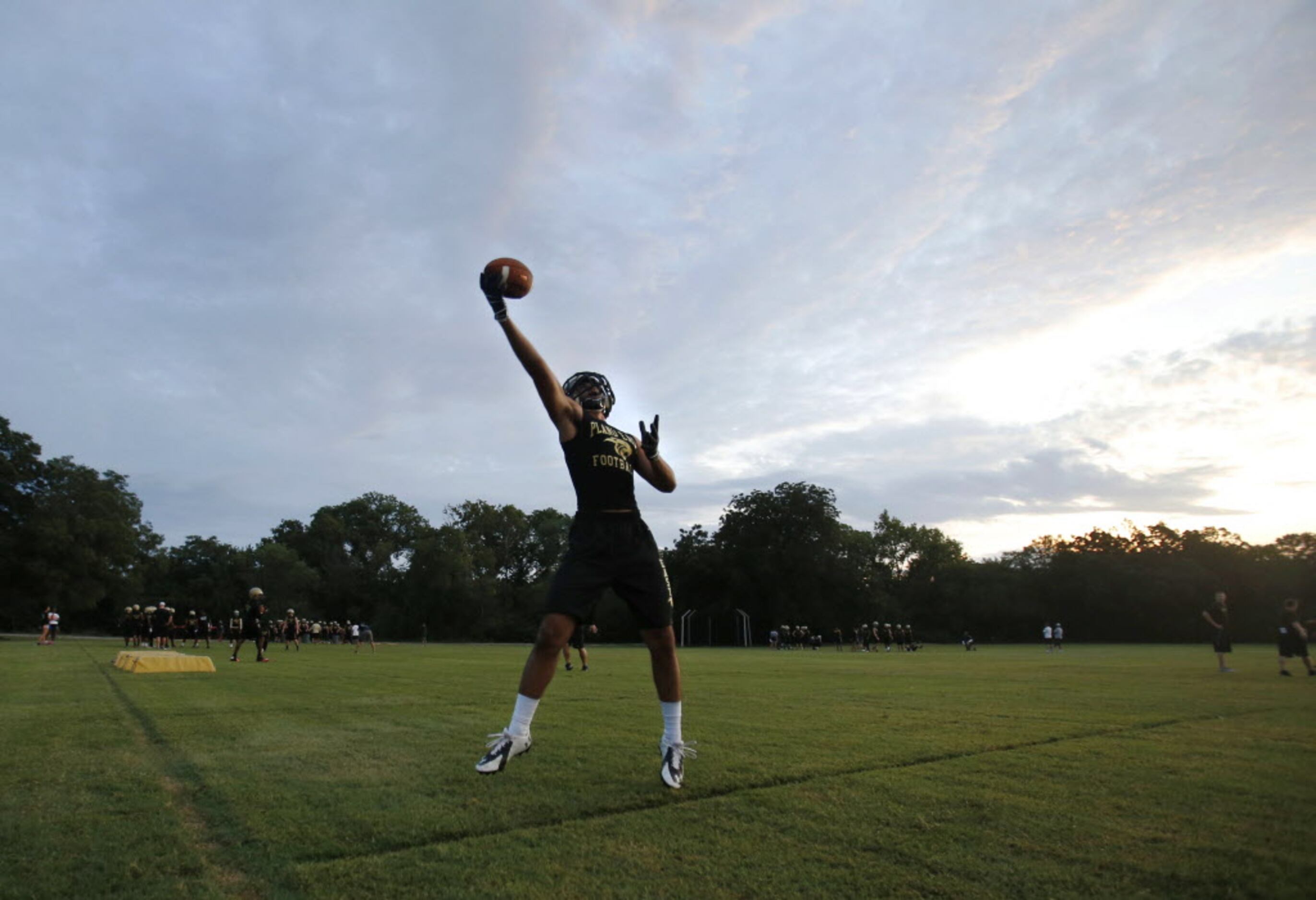 Plano East's Lahin Amlani makes a one handed catch during the first day of football practice...