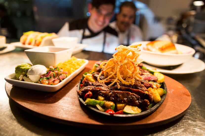A steak fajita skillet topped with fried onion strings is one of the dishes offered by...