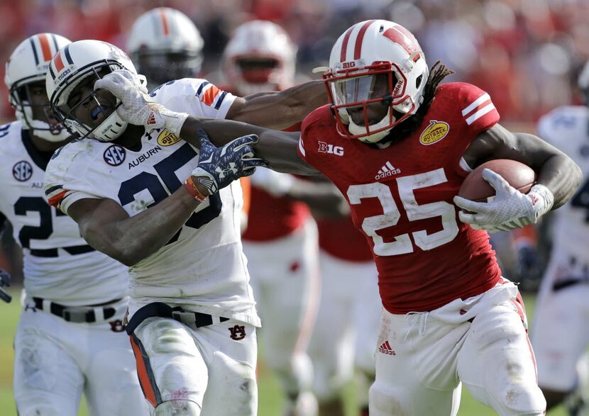 Wisconsin running back Melvin Gordon (25) stiff arms Auburn defensive back Jermaine...