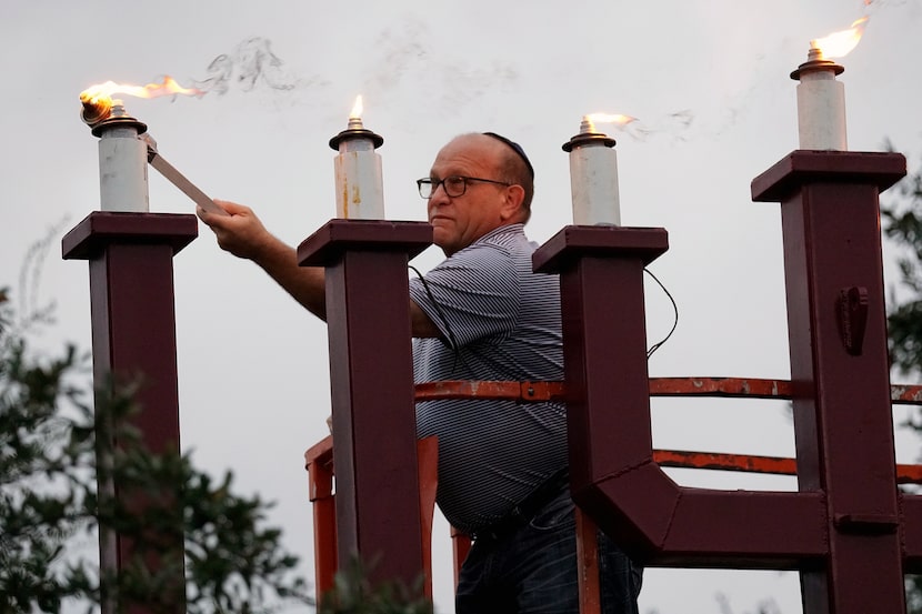 Artie Allen, of the Aaron Family Jewish Community Center of Dallas, lights the menorah...