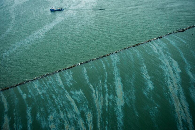 A vessel works to clean up spilled fuel oil near the Galveston Jetties.