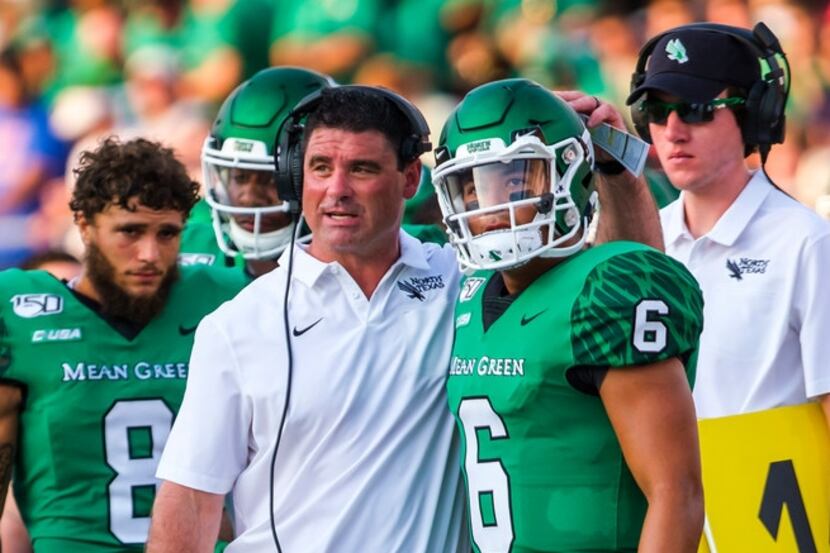 UNT head coach Seth Littrell talks with his players the sidelines during the first half...