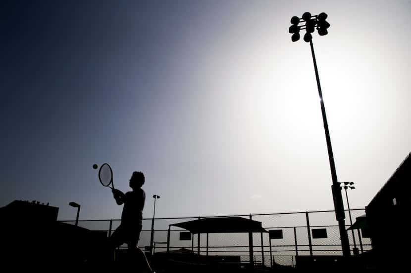 Antonio Sosa works on his backhand during a tennis lesson in 104 degree heat on Tuesday,...