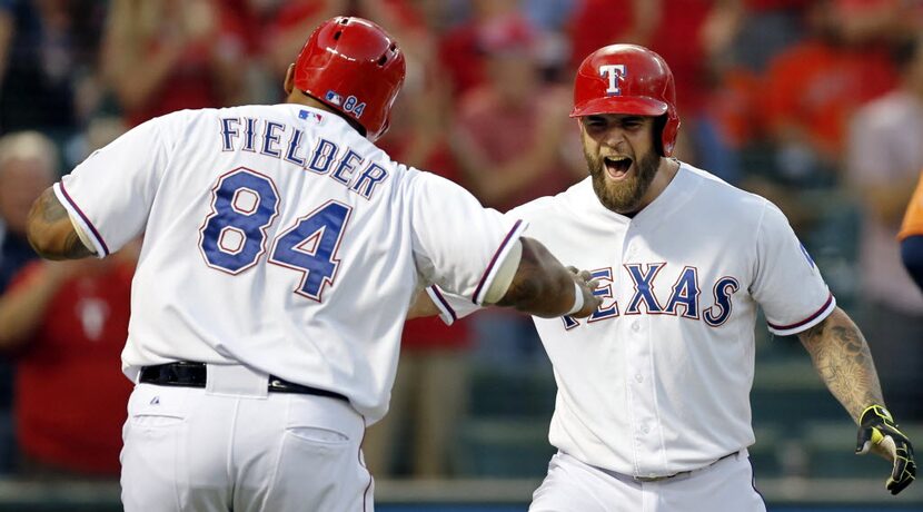 Texas Rangers left fielder Mike Napoli (right) high-fives designated hitter Prince Fielder...