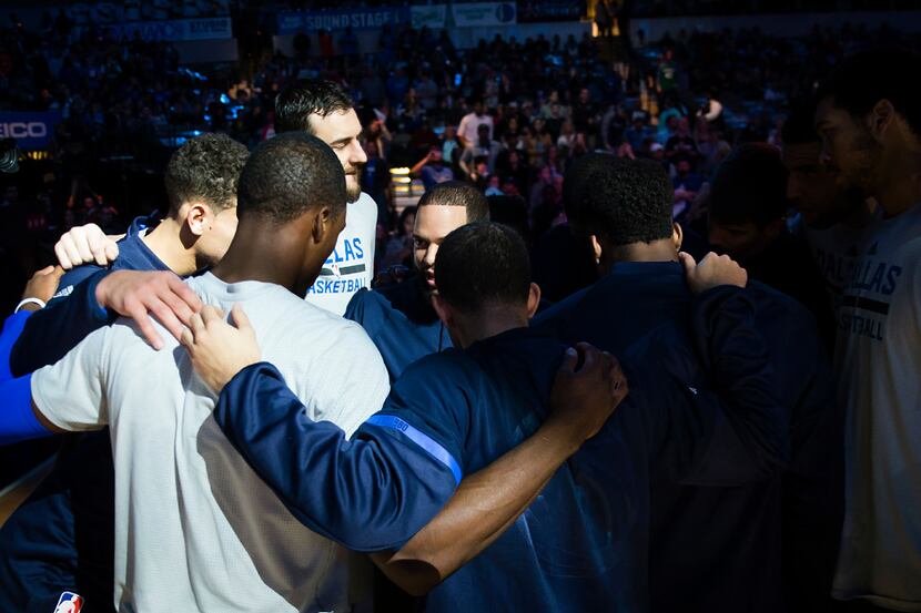 Dallas Mavericks players huddle before an NBA basketball game against the New Orleans...