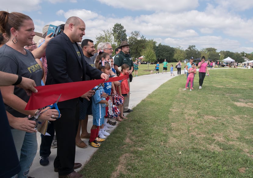 Dallas City Council Member Adam Medrano cuts a ribbon during the grand opening of Buckner...