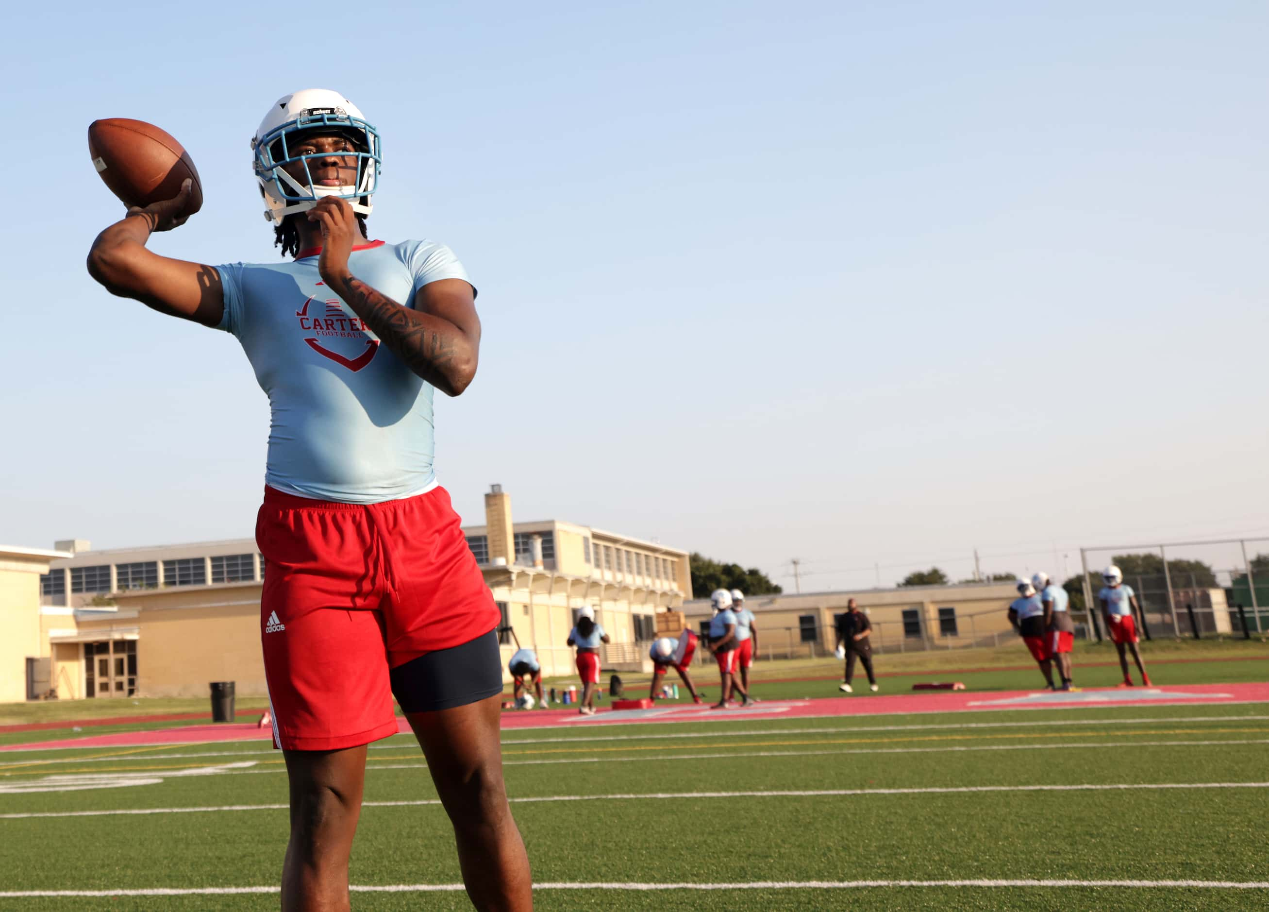 C.J. Miller throws the ball as players attend their first day of football practice at Carter...