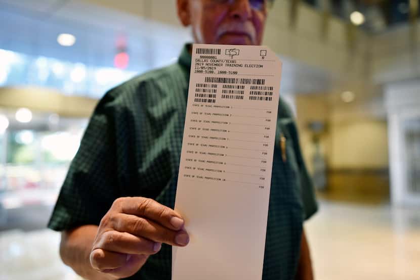 Ron Abraham, 75, of Mesquite, shows off his printed ballot before scanning his votes during...