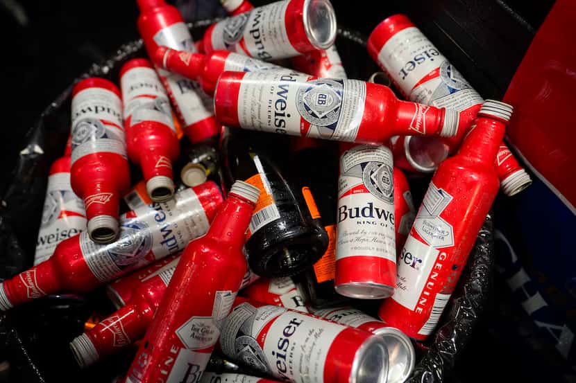 A trash bin is filled with empty beer and champagne bottles as the Texas Rangers celebrate...