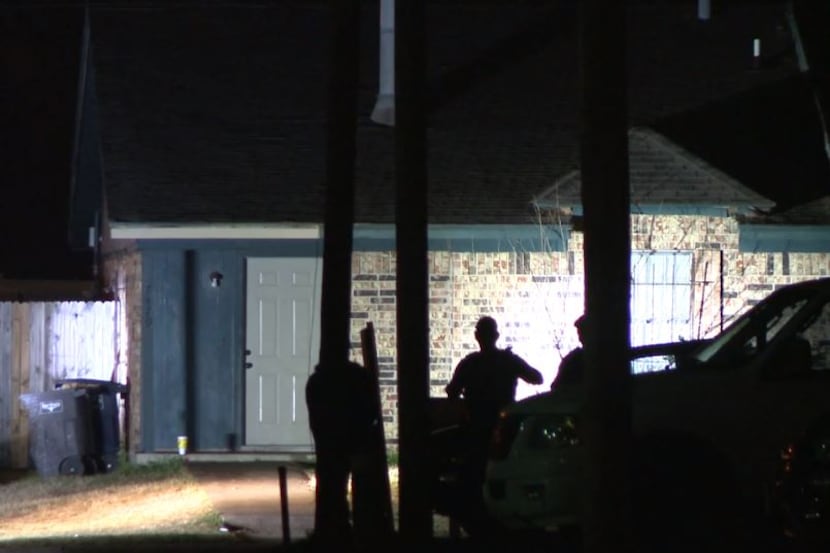 Fort Worth police officers keep an eye on a home after a man was shot in the area Monday...
