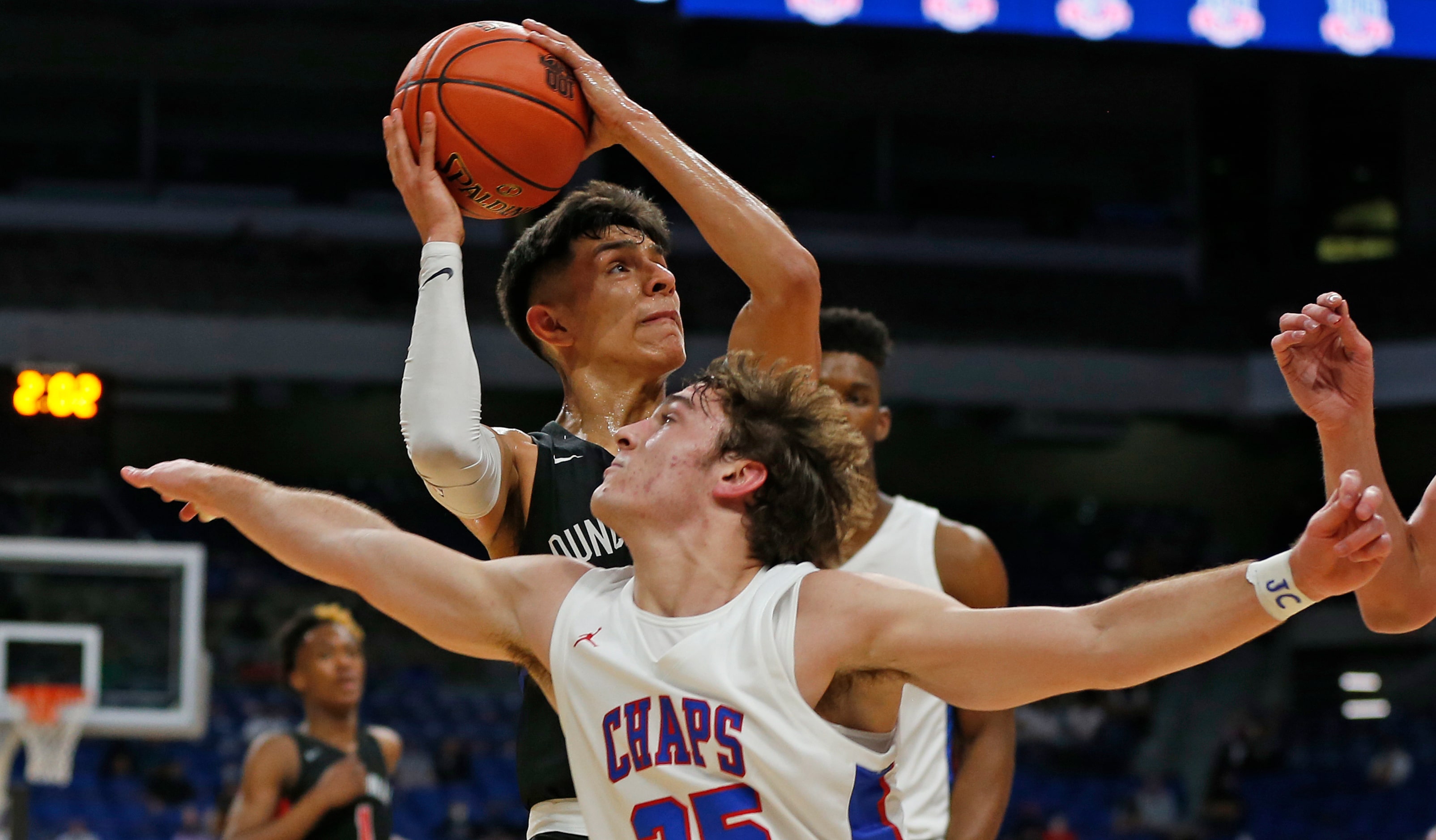 Duncanville Juan Reyna #20 drives by Westlake Eain Mowat #25. UIL boys Class 6A basketball...