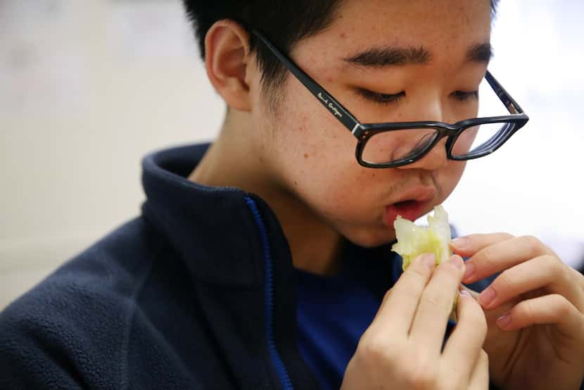 Junior Brice Chen eats part of his head of lettuce during a meeting of The Lettuce Club at...