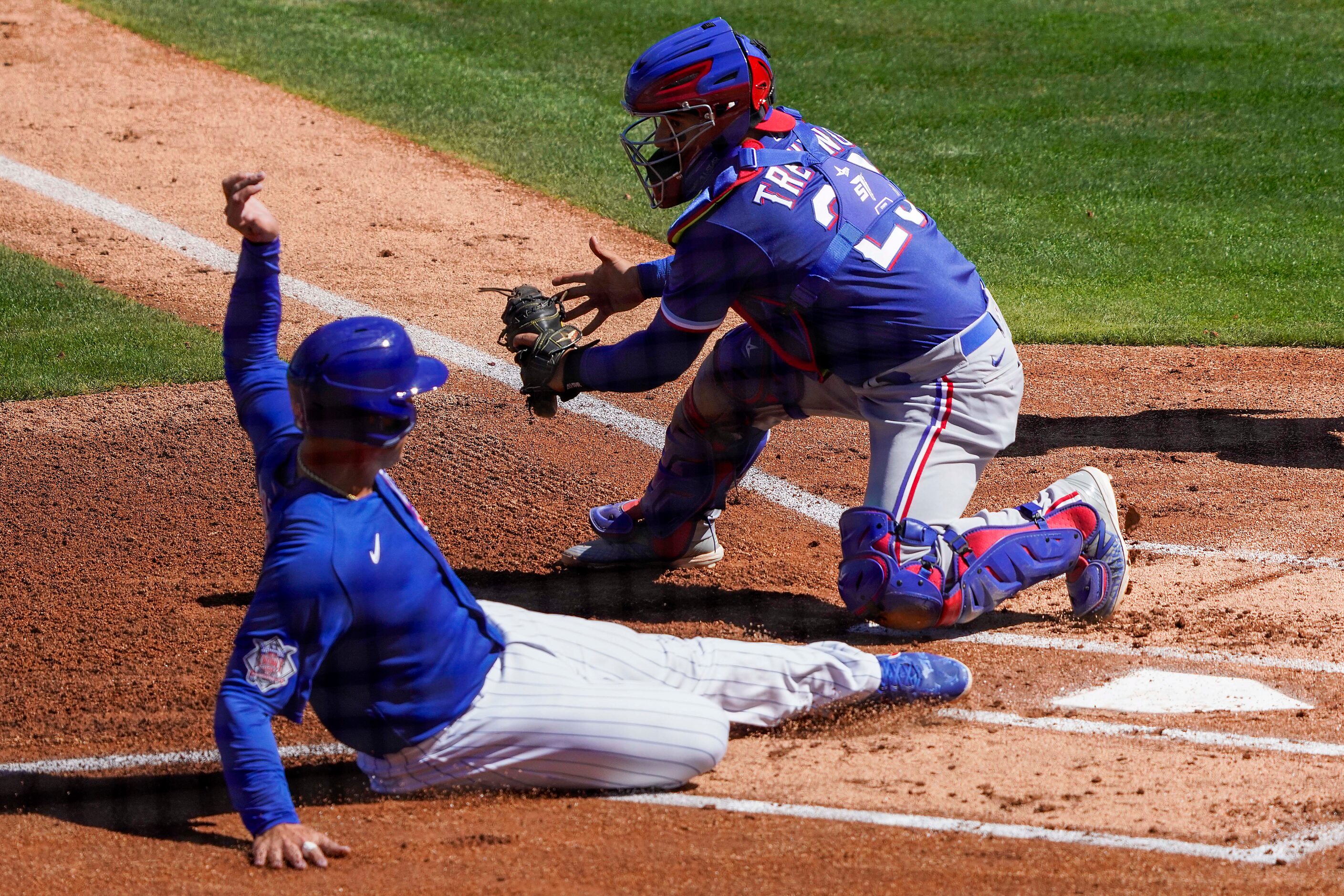 Chicago Cubs first baseman Anthony Rizzon scores ahead of tag from Texas Rangers catcher...