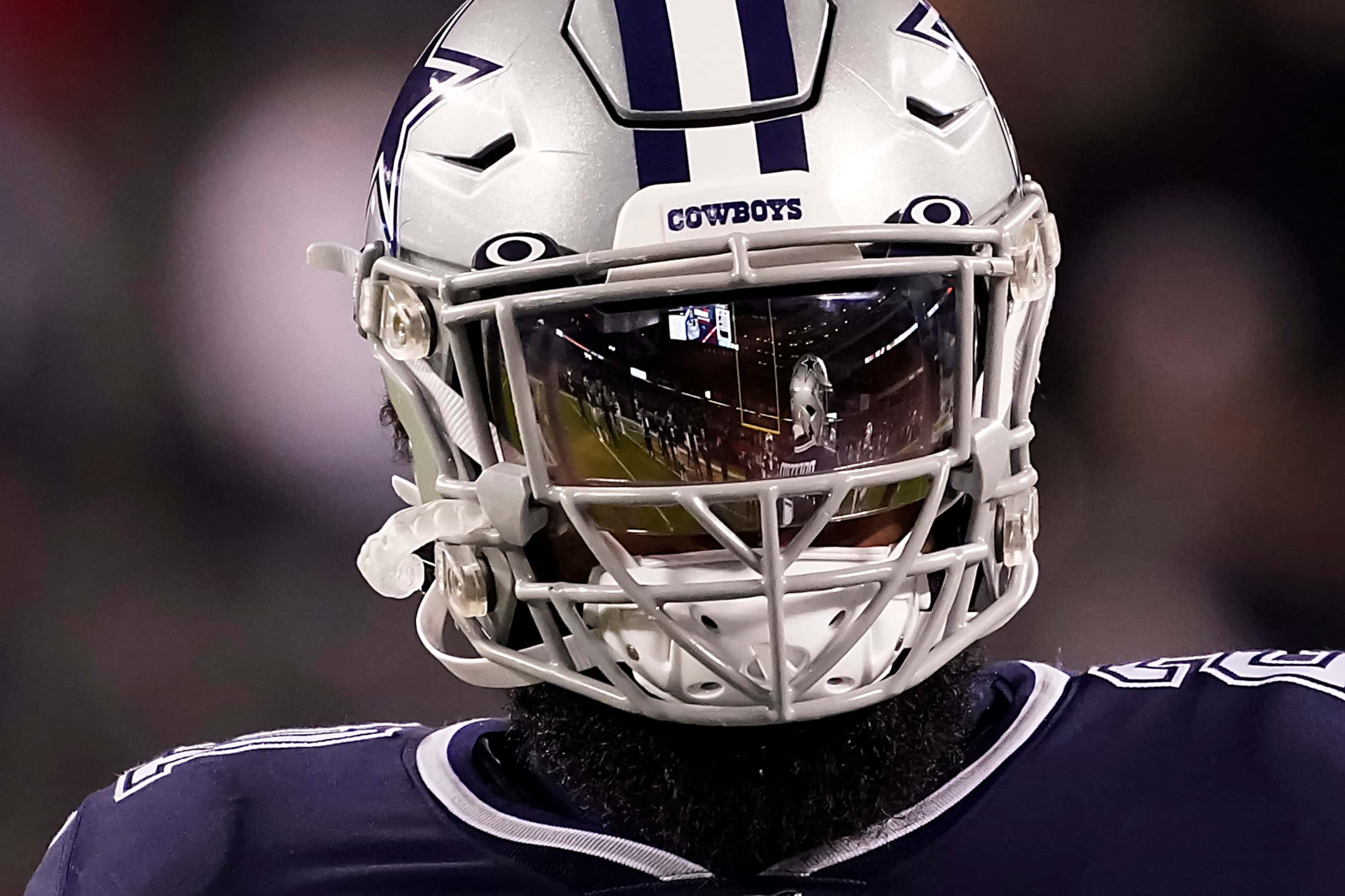 Dallas Cowboys quarterback Dak Prescott (4) is reflected in the visor of running back...