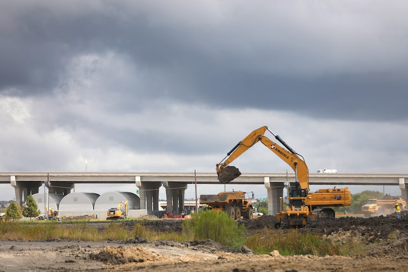 The Dallas North Tollway can be seen in the background as work is underway at Firefly Park,...