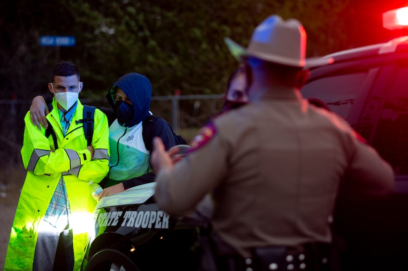 Franco Centeno, 27, left, shivers while he waits with a Texas Department of Public Safety...