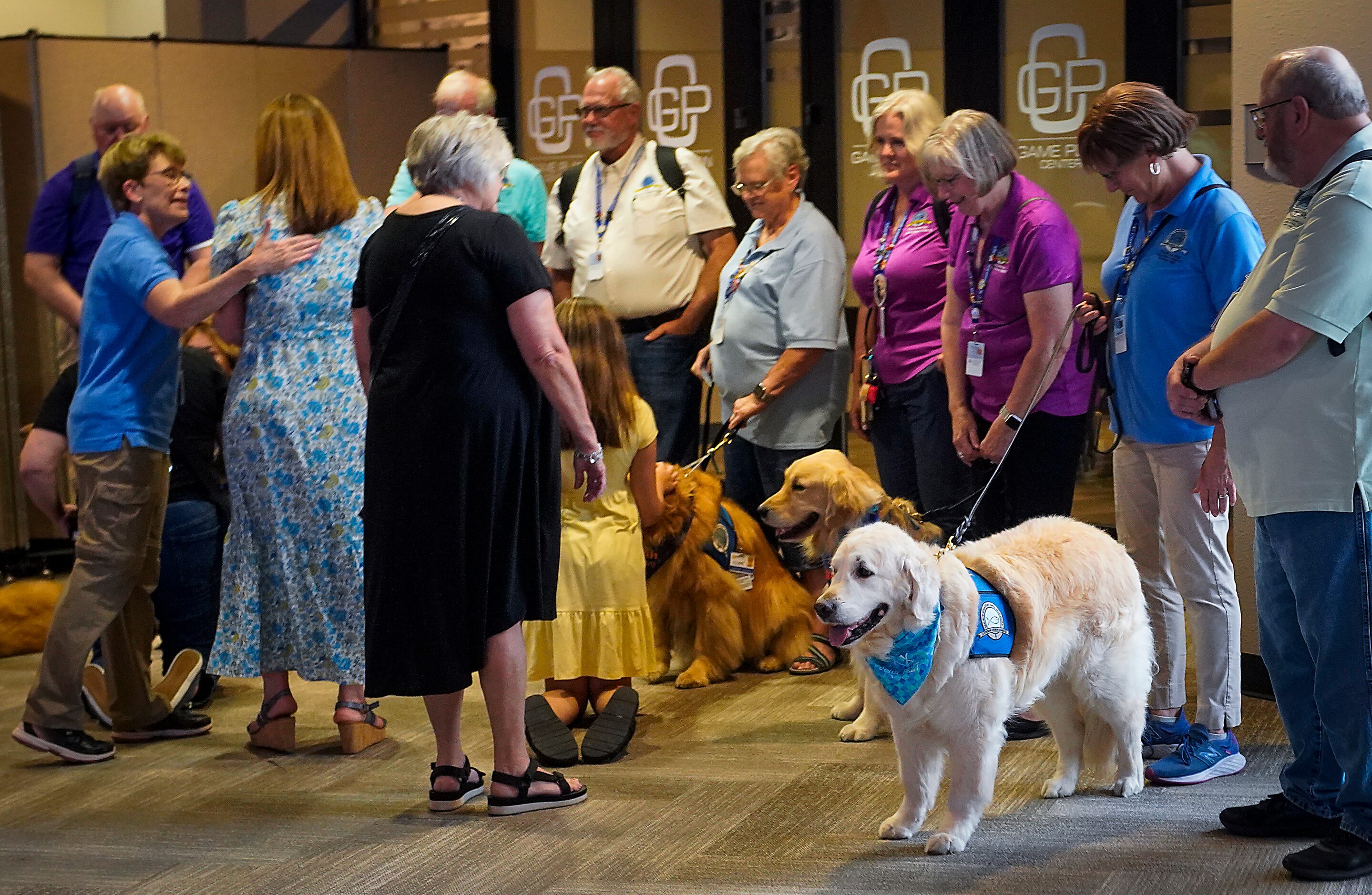 A group stages with therapy dogs before a vigil at Cottonwood Creek Church a day after a...