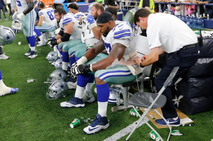 FILE - Dallas Cowboys head athletic trainer Jim Maurer tends to left tackle Tyron Smith (77)...