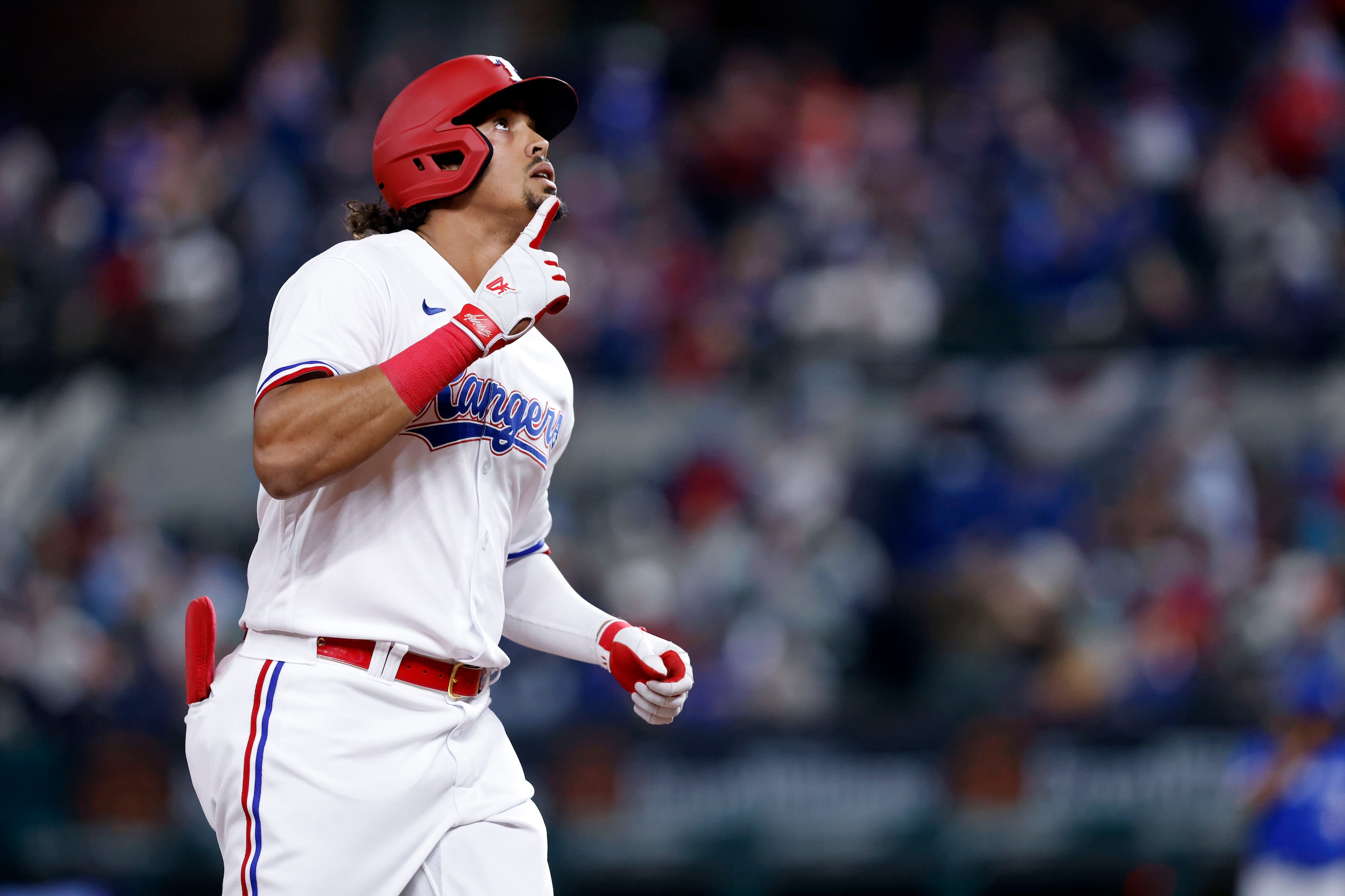 Texas Rangers Ronald Guzman points skyward after hitting a solo home run during second...