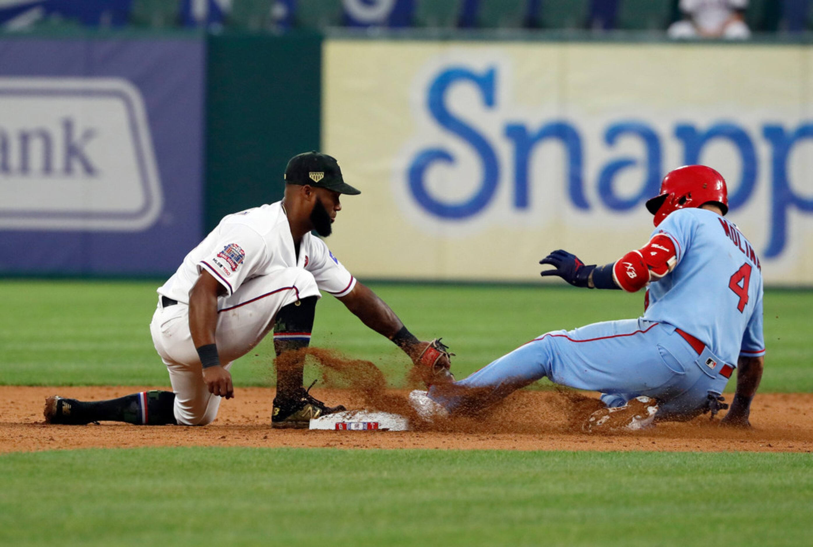 Texas Rangers shortstop Danny Santana is unable to tag out St. Louis Cardinals' Yadier...