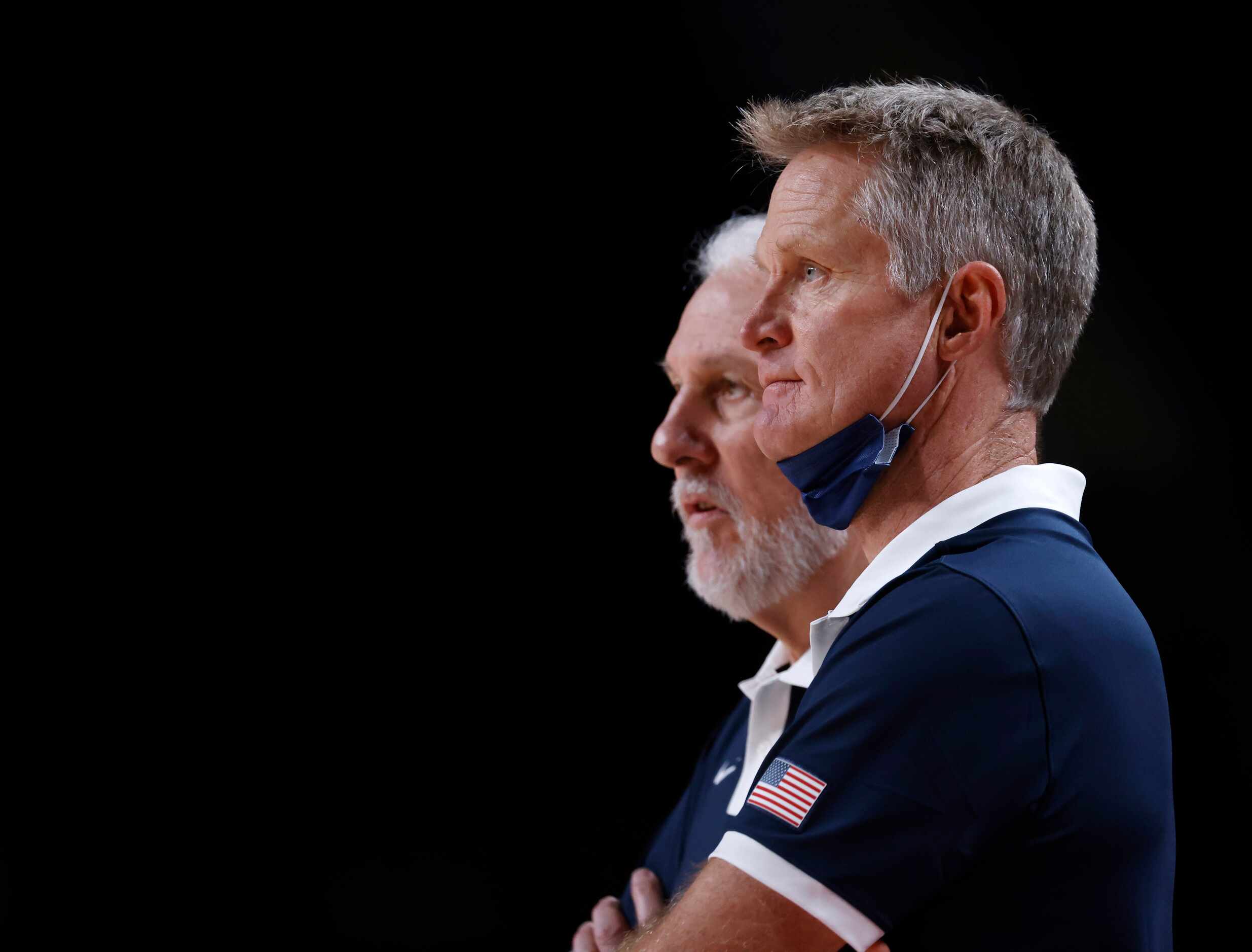 USA’s assistant coach Steve Kerr watches the game next to head coach Gregg Popovich as the...