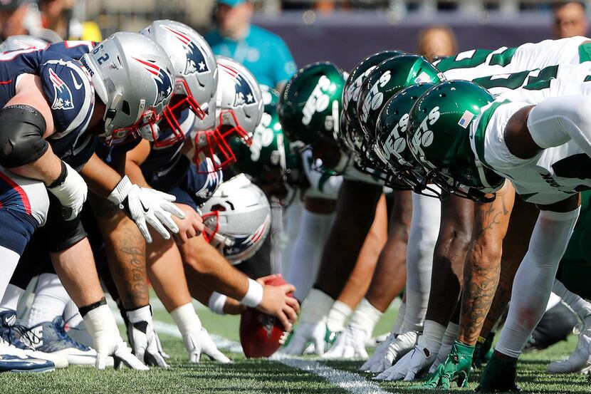 The New England Patriots and the New York Jets line up for the snap at the line of scrimmage...
