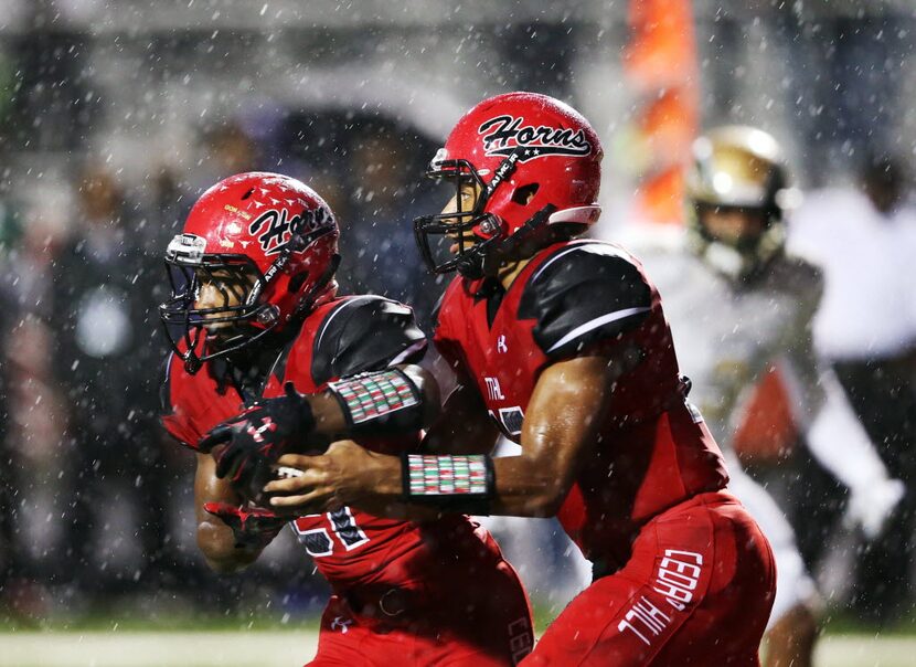 Cedar Hill's Avery Davis (12) fakes a handoff to Marquise Forman (21) in a game against...