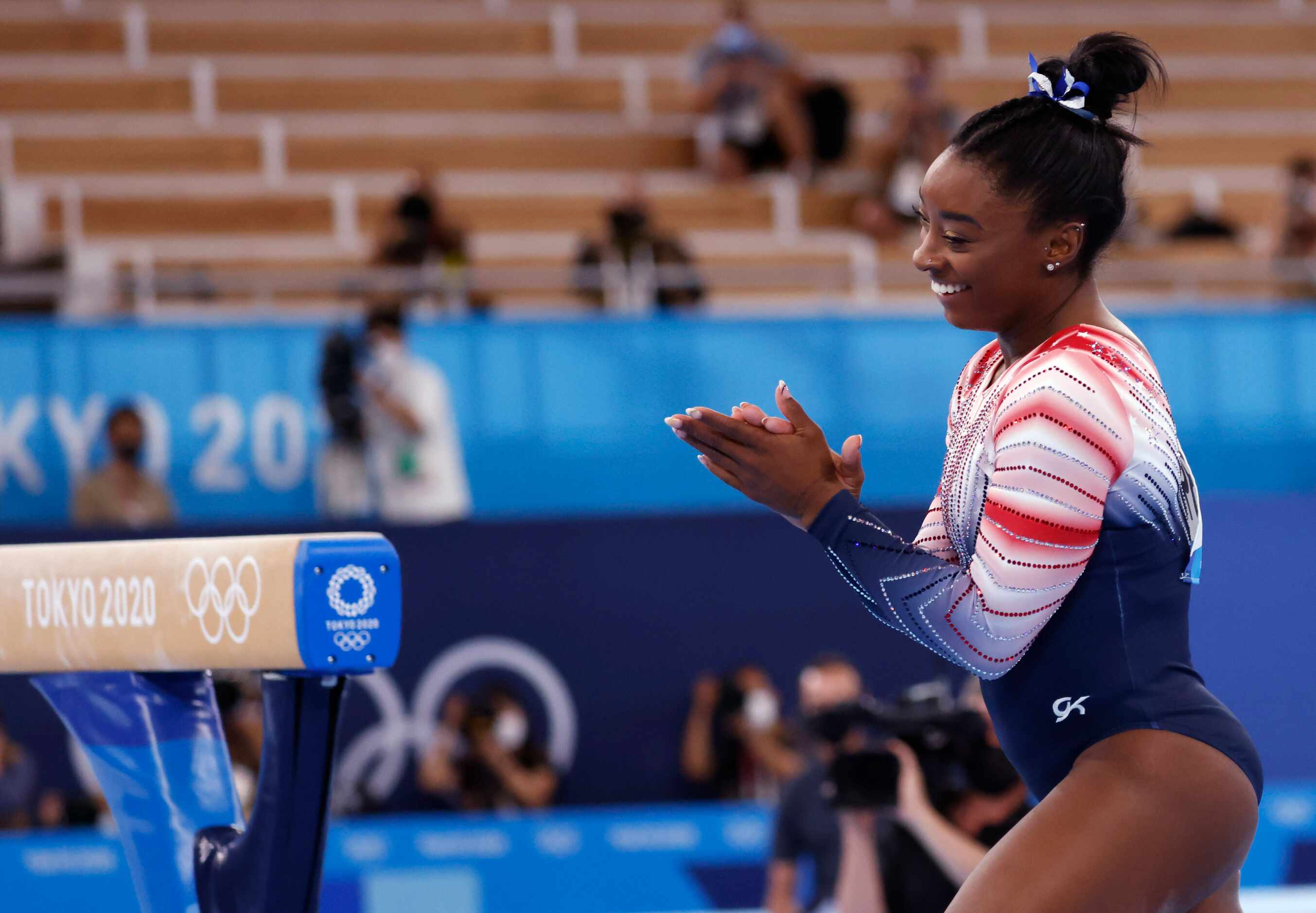 USA’s Simone Biles claps after competing in the women’s balance beam final at the postponed...