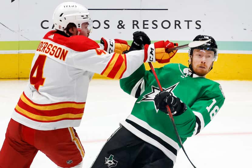 Dallas Stars left wing Michael Raffl (18) receives a high stick to the face from Calgary...