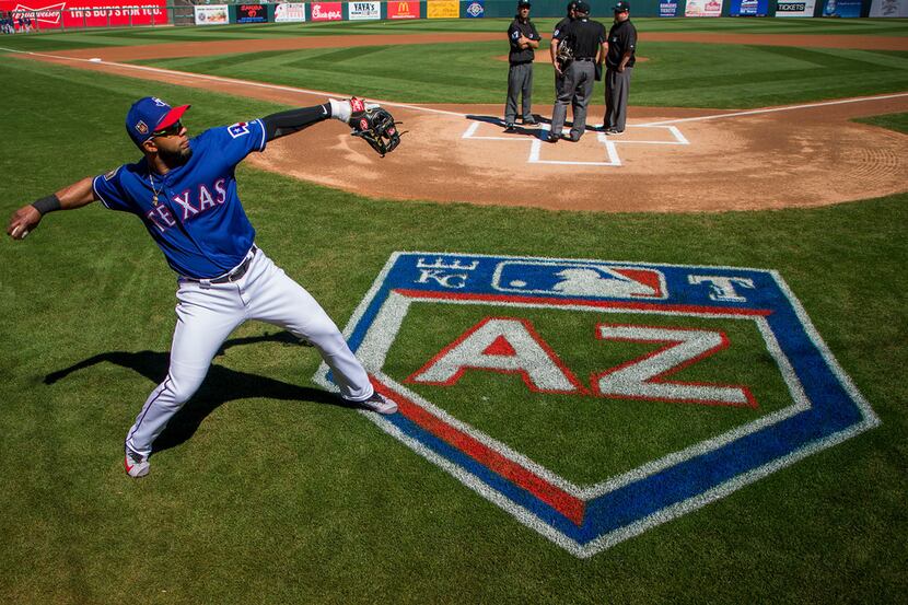Texas Rangers shortstop Elvis Andrus warms up before a spring training baseball game against...
