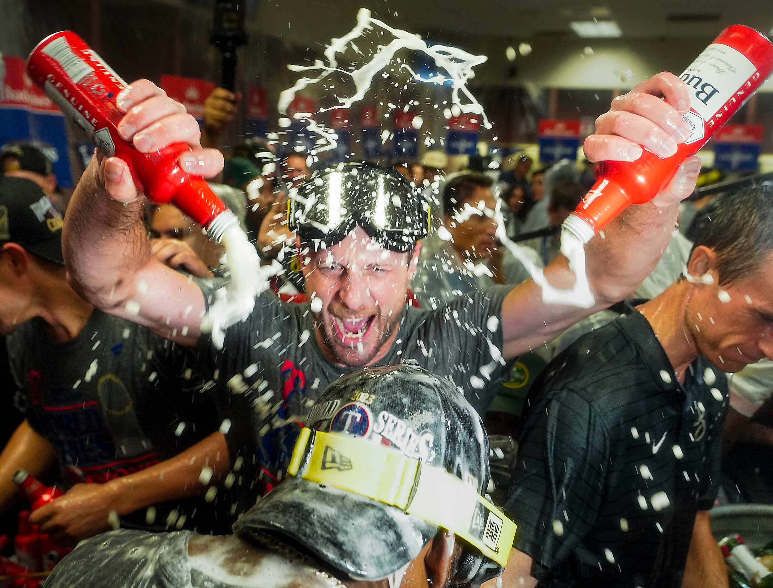 Texas Rangers players celebrate in the clubhouse after defeating the Arizona Diamondbacks in...