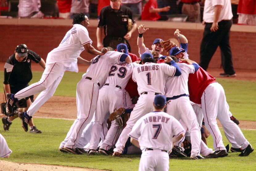 Texas Rangers designated hitter Vladimir Guerrero (27) leaps on his teammates after they...