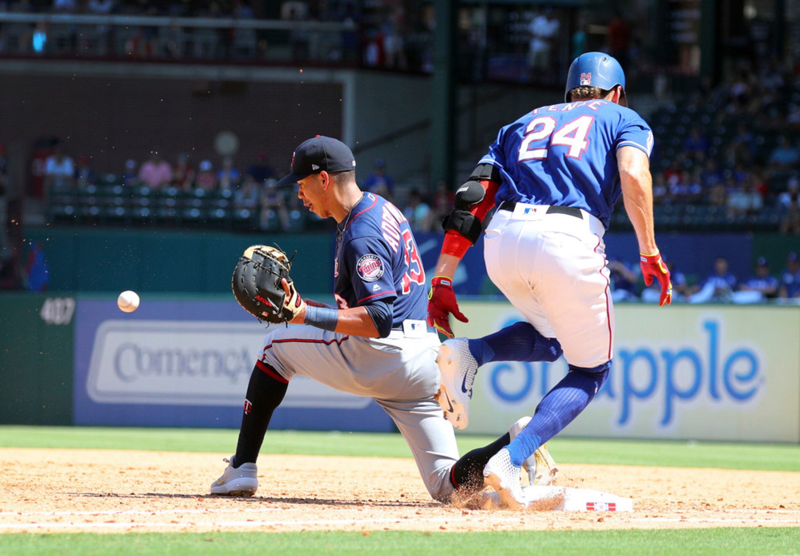 Minnesota Twins first baseman Ehire Adrianza (13) awaits the ball as Texas Rangers'Hunter...