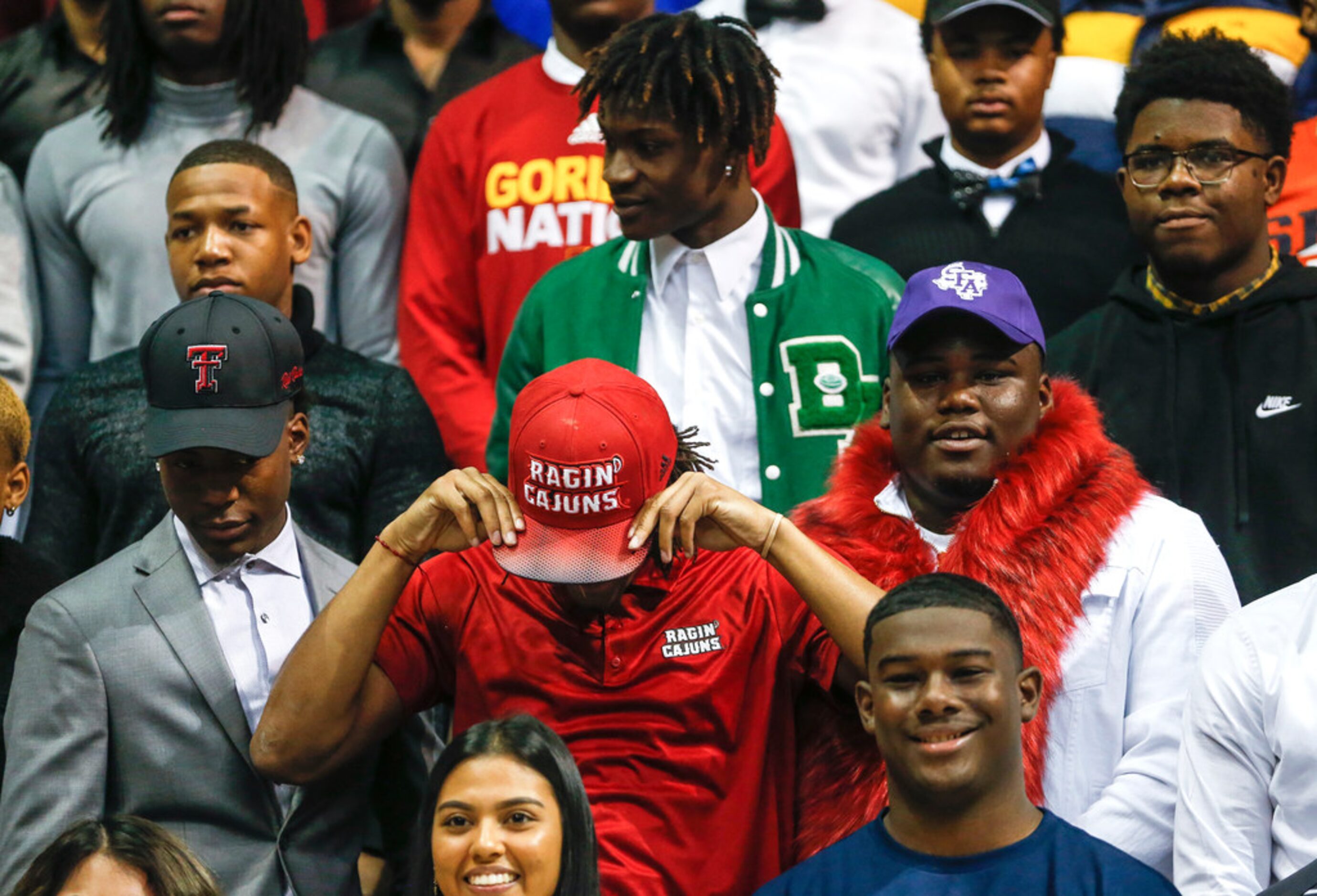 Players gather for a group photo during a Dallas ISD signing day event at Ellis Davis Field...