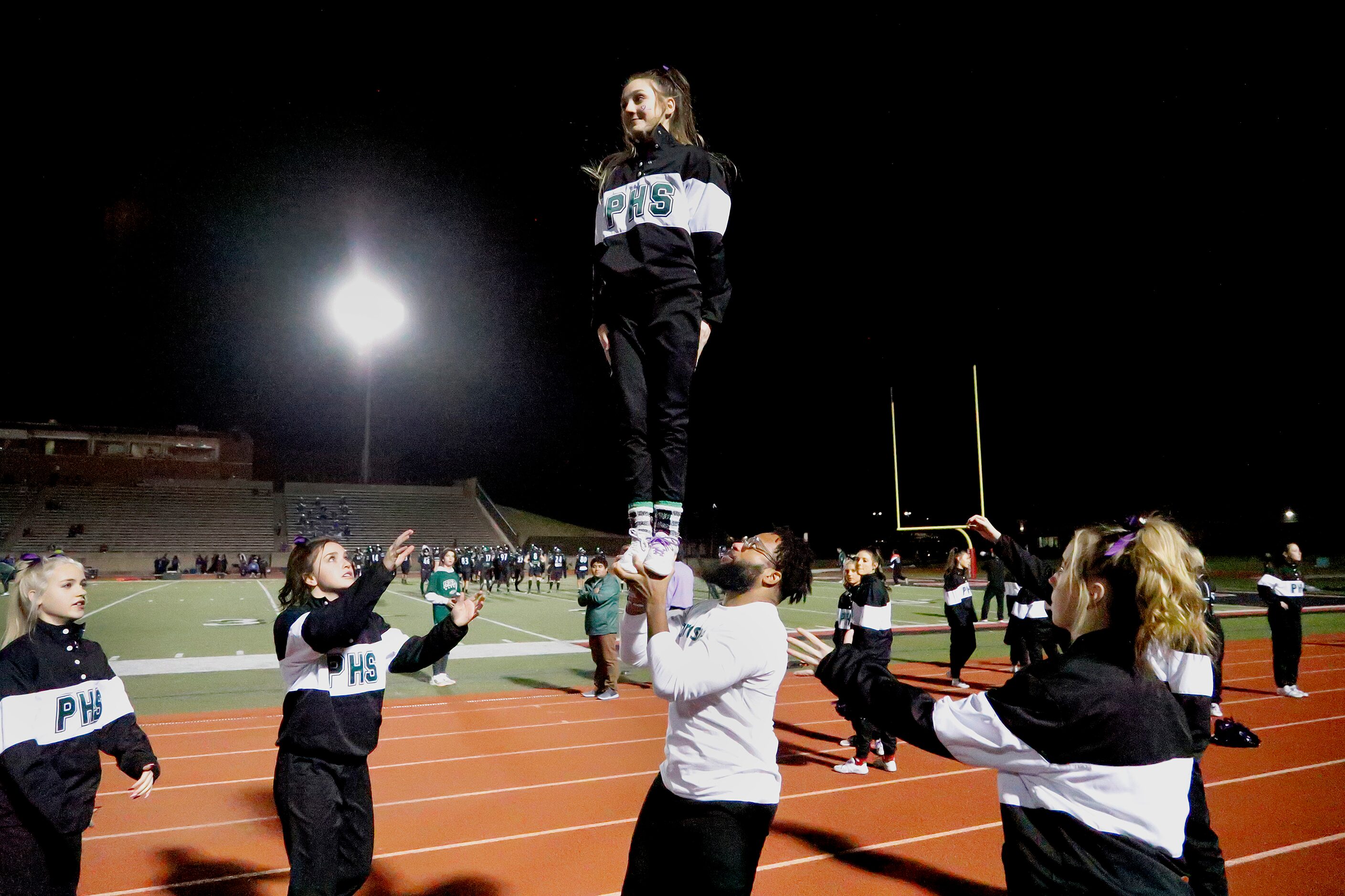 Prosper cheerleader Gabby Beaty, 16, is held up by Cameron Jones, head cheer coach befoer...