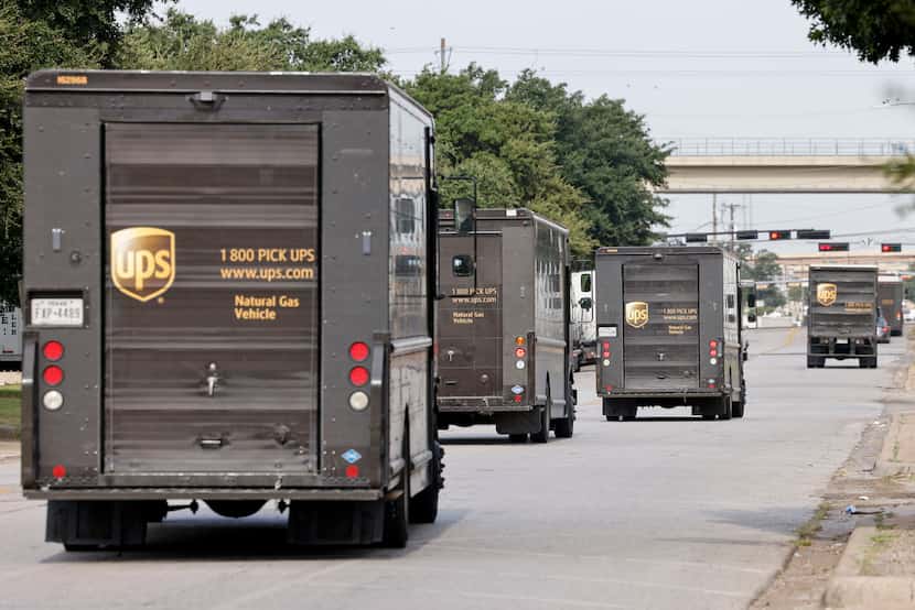 UPS delivery trucks leave a UPS distribution center in northwest Dallas, Friday, July 21, 2023.