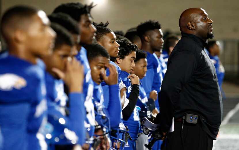Wilmer-Hutchins head coach Elzie Barnett stands with his team for the national anthem before...