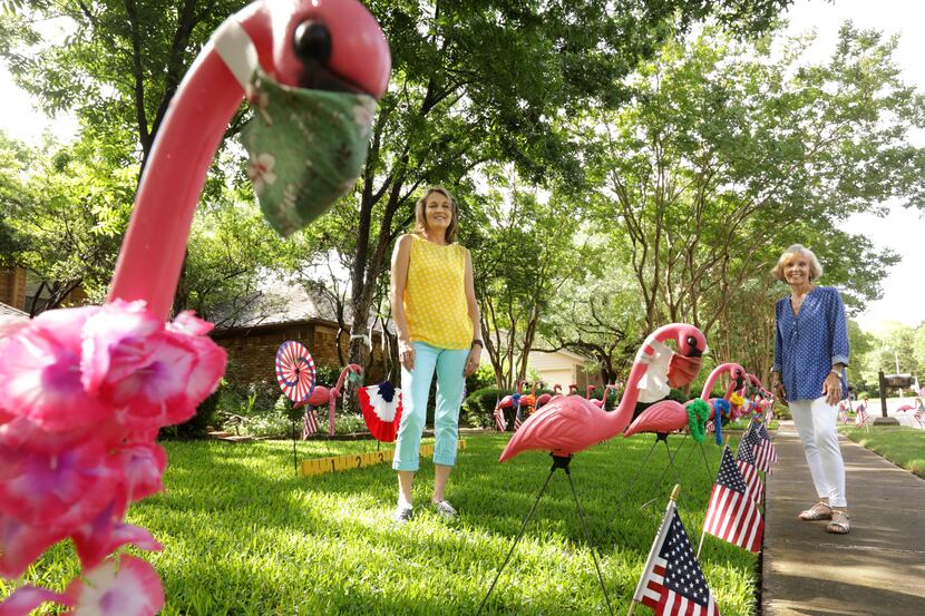 Annette Hansen (left) and Joanie Moi create displays with plastic flamingos placed outside...