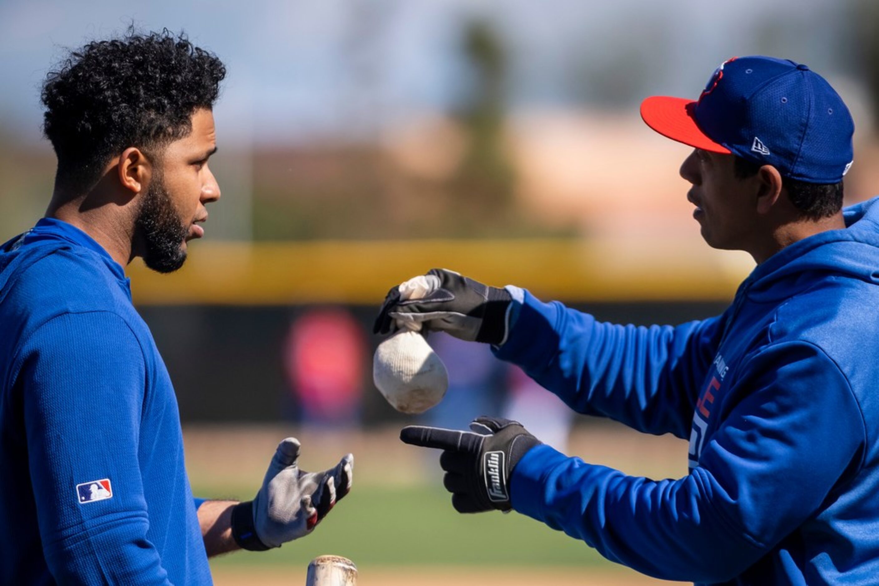 Texas Rangers hitting coach Luis Ortiz works shortstop Elvis Andrus during a spring training...