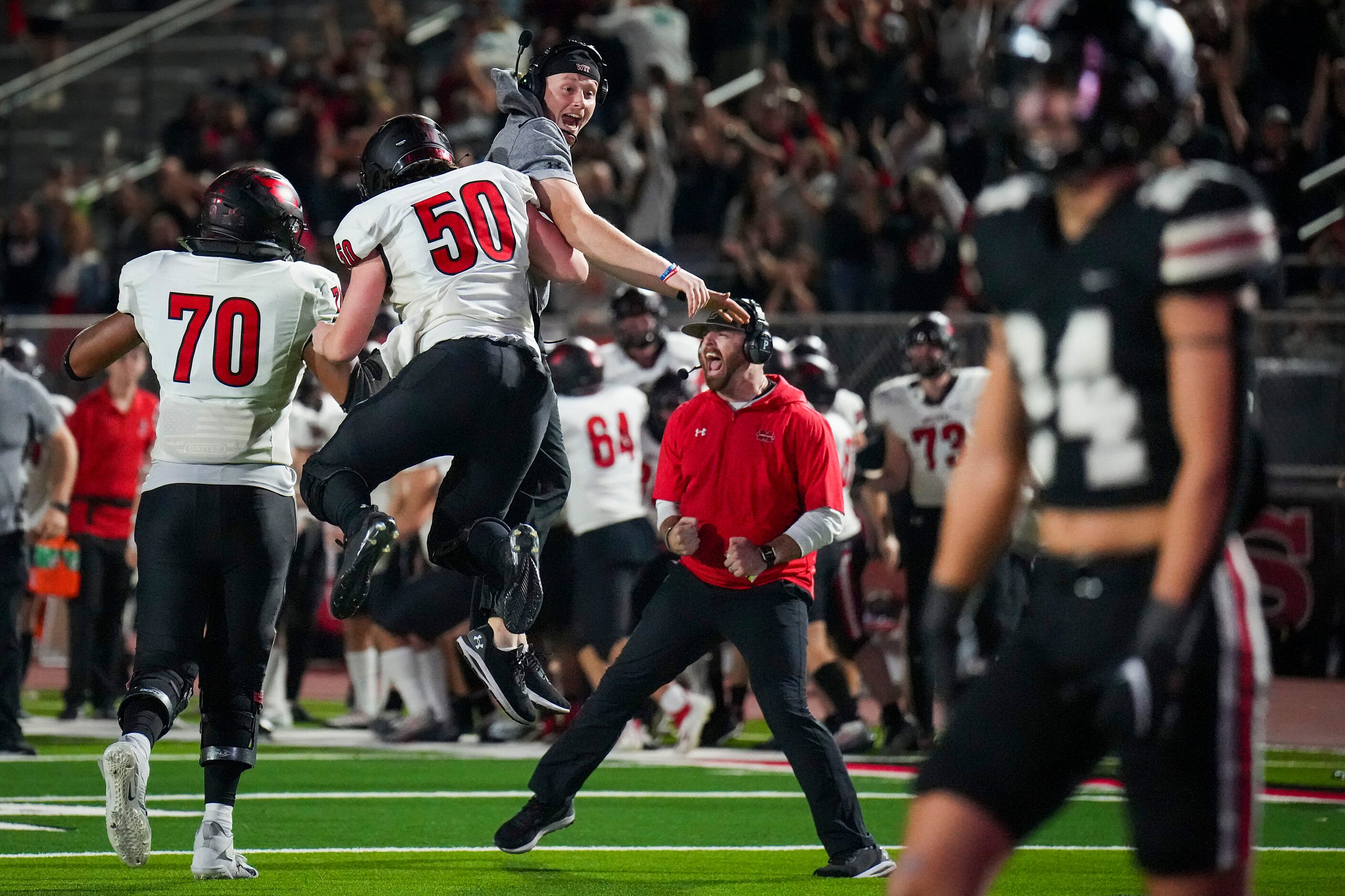 Melissa lineman Luke Demel (50) and lineman Trevor Goosby (70) celebrate with coaches after...