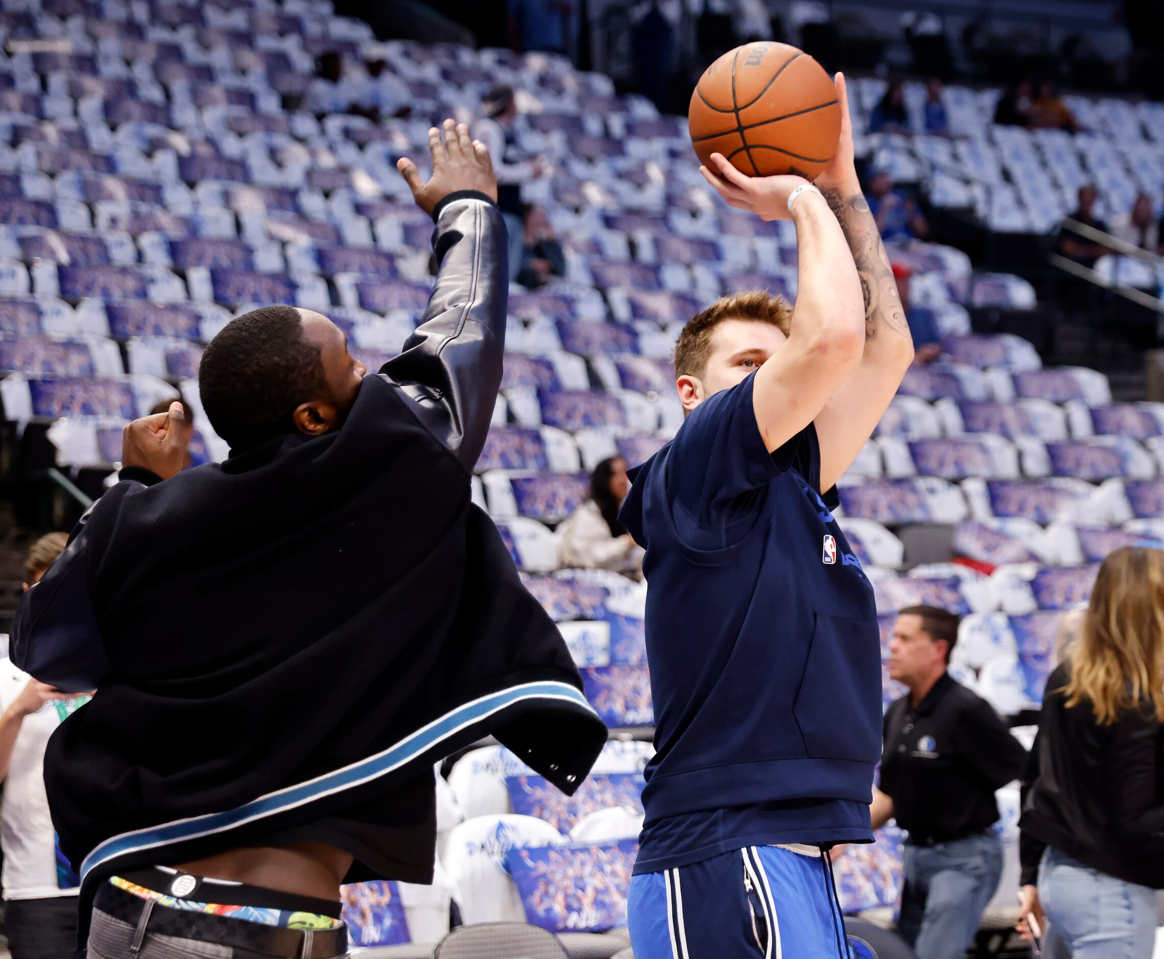 Dallas Mavericks guard Theo Pinson (left) tries to block a shot by teammate Luka Doncic...