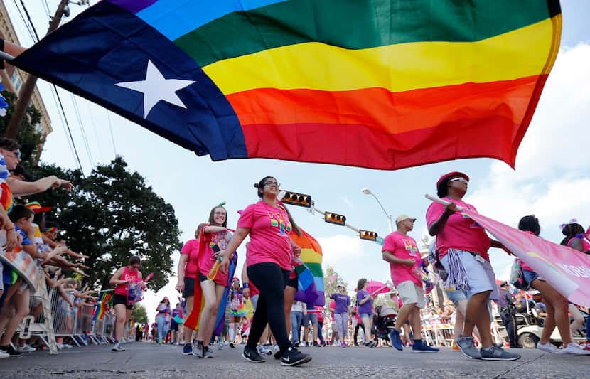 People marching with the Mobilize for Equality group passed by a Texas rainbow flag during...