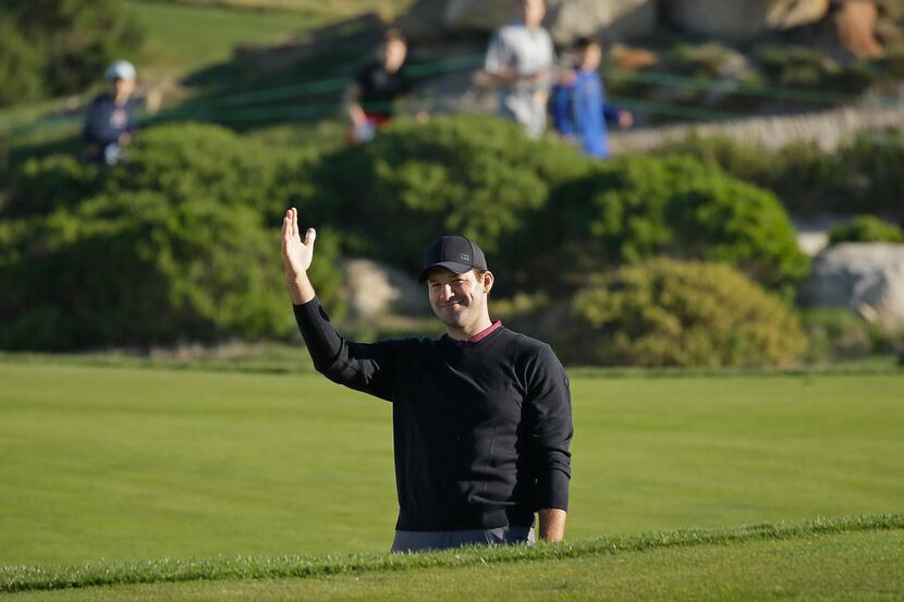 Tony Romo waves after hitting the ball out of a bunker and close to the pin on the 11th...