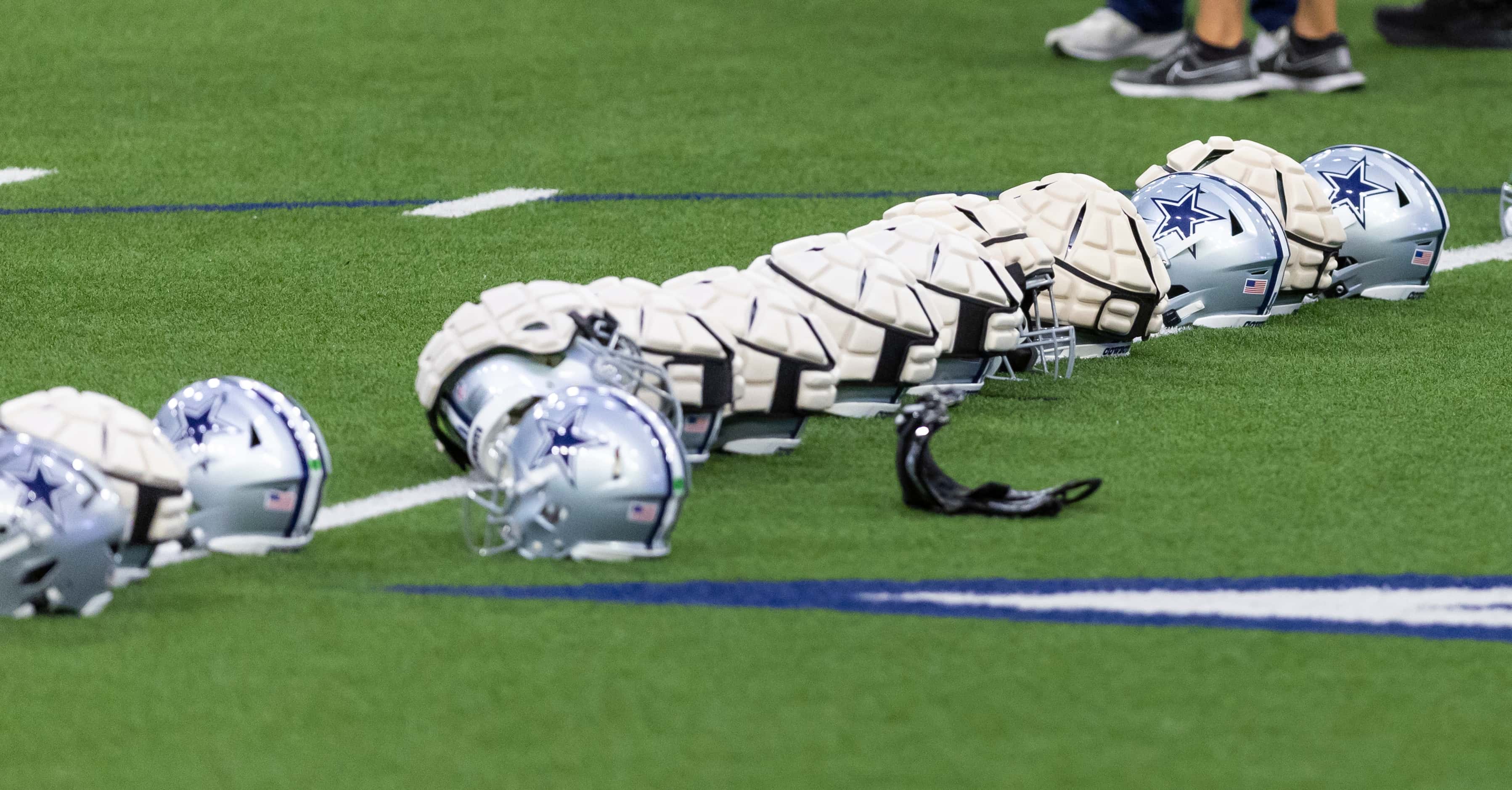 Padded covers are seen on several Dallas Cowboys helmets during a minicamp practice at The...